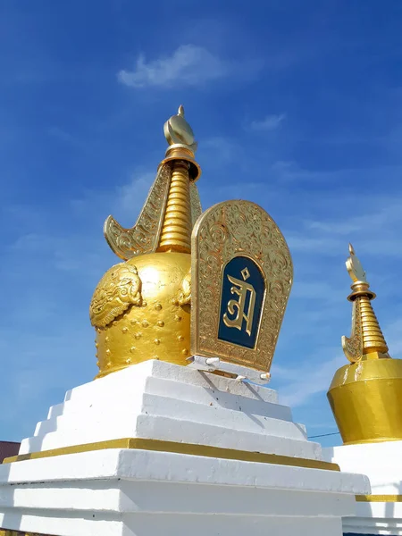 Budist, beyaz taş bir anıt altın tepeli sembolik bir süsleme ile yaz günü mavi gökyüzü ile 