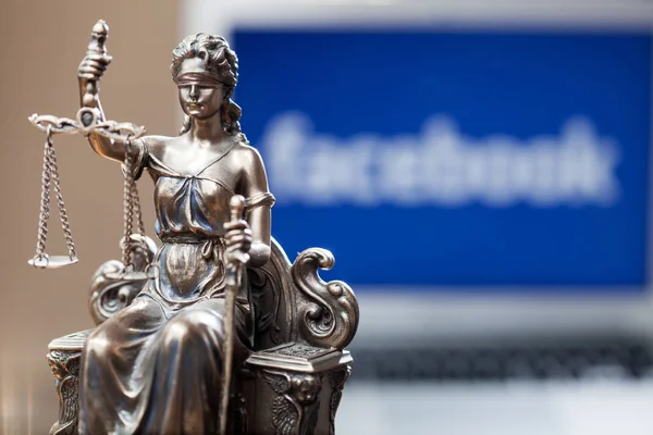 Belgrad / Serbien - 18. Juni 2019: Eine mit verbundenen Augen gefaltete Justizstatue vor einem Laptop mit dem Facebook-Logo des sozialen Netzwerks auf dem Bildschirm, das die Einführung der Kryptowährung "Libra" von Facebook darstellt." — Stockbild Belgrad Serbien Juni 2019 Eine Mit Verbundenen Augen Gefaltete Justizstatue — Stockfoto