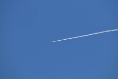 Kondensstreifen eines Flugzeuges im blauen Himmel ueber Liechtenstein