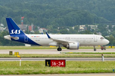 Zürih, İsviçre, 5 Ağustos 2025 SE-RZX SAS Scandinavian Airlines Airbus A320-251N uçağı kapıya yanaşıyor.