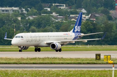 Zürih, İsviçre, 5 Ağustos 2025 SE-RSK SAS İskandinav Havayolları Embraer E195LR uçağı kapıya doğru ilerliyor.