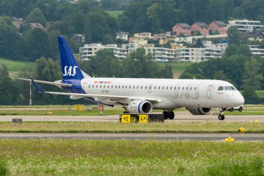 Zürih, İsviçre, 5 Ağustos 2025 SE-RSK SAS İskandinav Havayolları Embraer E195LR uçağı kapıya doğru ilerliyor.