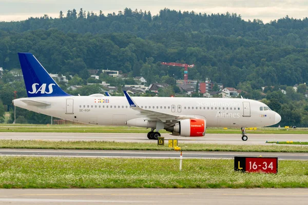 Zürih, İsviçre, 5 Ağustos 2025 SE-ROP SAS Scandinavian Airlines Airbus A320-251N uçağı kapıya yanaşıyor.