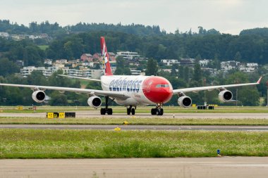 Zürih, İsviçre, 5 Ağustos 2025 HB-JMG Edelweiss Air Airbus A340-313 uçakları kapıya yanaşıyor.