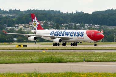 Zürih, İsviçre, 5 Ağustos 2025 HB-JMG Edelweiss Air Airbus A340-313 uçakları kapıya yanaşıyor.