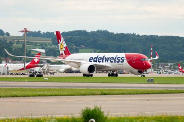 Zürih, İsviçre, 5 Ağustos 2025 HB-IHF Edelweiss Air Airbus A350-941 uçağı kapıya yanaşıyor.