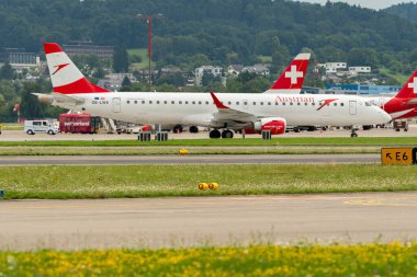Zürih, İsviçre, 5 Ağustos 2025 OE-LWK Avusturya Havayolları Embraer E195LR uçağı kapıya doğru ilerliyor.