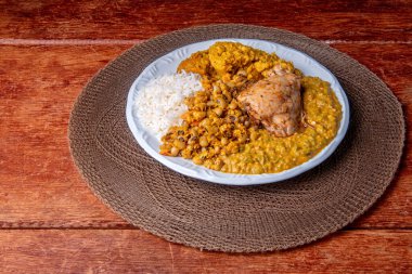 Geleneksel Afro Brezilya yemeği bamya ve kurutulmuş karidesle yapılıyor yanında da vatap, fasulye, pilav, tavuk ve manyok unu var..