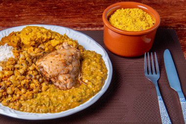 Geleneksel Afro Brezilya yemeği bamya ve kurutulmuş karidesle yapılıyor yanında da vatap, fasulye, pilav, tavuk ve manyok unu var..