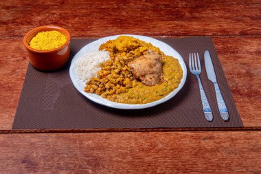 Geleneksel Afro Brezilya yemeği bamya ve kurutulmuş karidesle yapılıyor yanında da vatap, fasulye, pilav, tavuk ve manyok unu var..