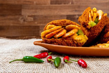 Vatapa, caruru, domates salatası ve karidesle doldurulmuş siyah bezelyeli ve soğanlı geleneksel Brezilya hamur tatlısı. Tipik Bahia yemekleri..