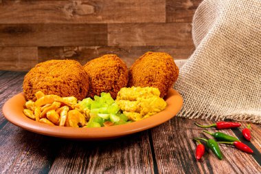 Vatapa, caruru, domates salatası ve karidesle doldurulmuş siyah bezelyeli ve soğanlı geleneksel Brezilya hamur tatlısı. Tipik Bahia yemekleri..