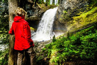 Moul Falls Grouse Creek Wells gri Provincial Park Clearwater, British Columbia, Kanada, büyük su akışını bakarak kırmızı yağmurluk kadında