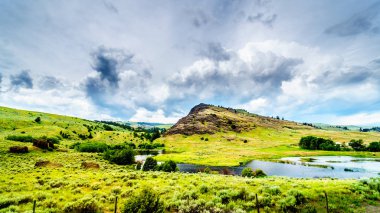 Rocky Mountain karanlık bulutlu gökyüzü altında Merritt ve Kamloops, British Columbia, Kanada arasında Otoban 5a boyunca Nicola Vadisi'nde tepeler arasında