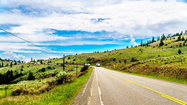 Heavy Truck Traffic on Highway 5A, a bypass route for the Coquihall Highway, winding through the wide open Grass Lands of the Nicola Valley, between Merritt and Kamloops, British Columbia, Canada