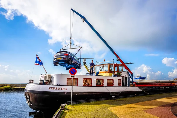 在荷兰乌尔克的历史和旅游渔村停泊的一艘大莱茵河船上卸下的汽车 — 图库照片