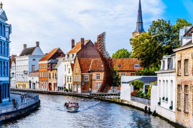 Bruges, Belçika çelik Lanchals heykel ve sağdaki St. Anna Kilisesi'nin Kulesi tarihi şehir St. Annarei kanalda kanal tekne turuna