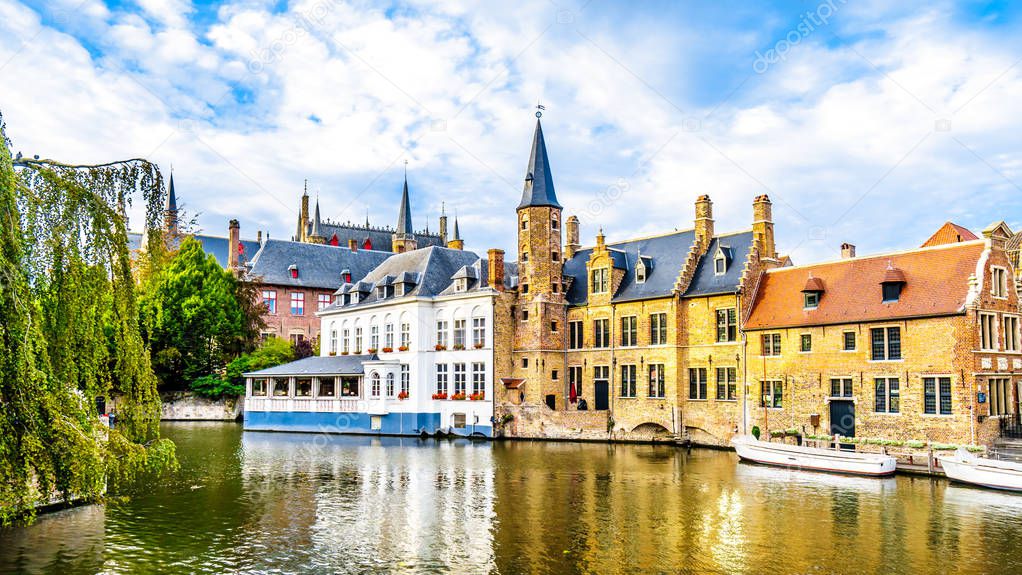 View of the historic buildings and the tower of the Huidenvettershuis at the Dijver Canal in the medieval city of Bruges, Belgium