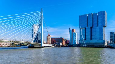 Rotterdam/the Netherlands - Sept. 26, 2018: Modern architectural High Rise buildings at the Holland Amerikakade with the Cable-Stayed Erasmus Bridge over the Nieuwe Maas River in Rotterdam clipart