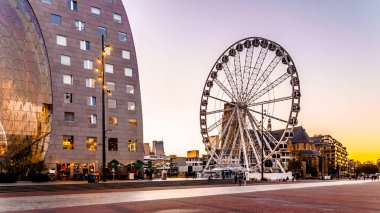 Rotterdam / Hollanda - 26 Eylül 2018: arka planda merkezi Rotterdam alacakaranlıkta Market Hall square yakınındaki Ortaçağ Saint Laurens kilisede ile Modern dönme dolap