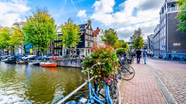 Amsterdam, Noord Holland/Hollanda - 3 Ekim 2018: bisiklet ve Amsterdam Merkez Kherengracht kanalda Herenstraat köprüden çiçekler
