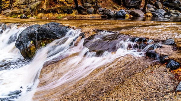 After heavy rainfall, water from Oak Creek flooding the road crossing Oak Creek at Orchard Canyon at Arizona SR89A between Sedona and Flagstaff in northern Arizona, United States of America