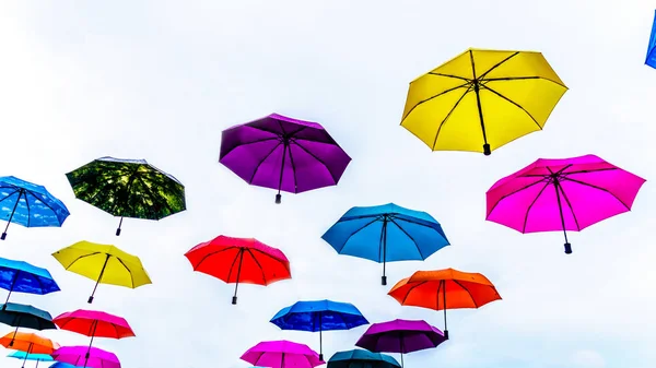 Colorful Umbrellas floating in the air under cloudy sky — Stock Image Colorful Umbrellas Floating Air Cloudy Sky Stock Photo