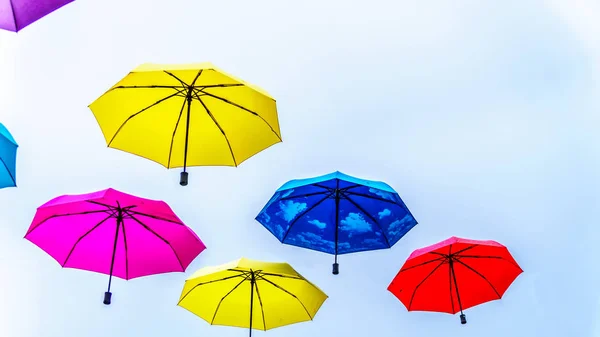 Colorful Umbrellas floating in the air under cloudy sky — Stock Image Colorful Umbrellas Floating Air Cloudy Sky Royalty Free Stock Photos