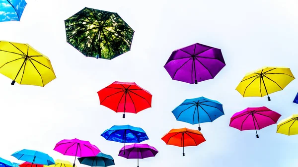 Colorful Umbrellas floating in the air under cloudy sky — Stock Image Colorful Umbrellas Floating Air Cloudy Sky Stock Picture