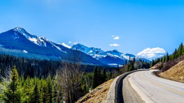 View of the snow capped Coast Mountains along Highway 99, also called The Duffey Lake Road, as it winds through the Coast Mountain Range between Pemberton and Lillooet in southern British Columbia clipart