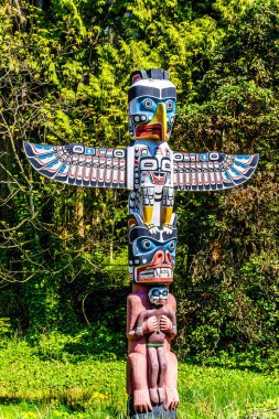 Renkli 'Thunderbird House Post Totem Pole' Totem kutup üstünde bir Thunderbird vardır, sonra altında bir Grizzly ayı bir insan tutan