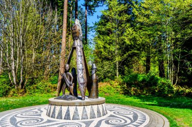 Vancouver. Bc/Canada-May 24, 2019: Portekiz cerebu heykeli Stanley Park'ta bronz bir heykeldir. Bu bölgenin aborijin ve Portekizce topluluklar arasında atalarının bağlantı bir haraç olduğunu