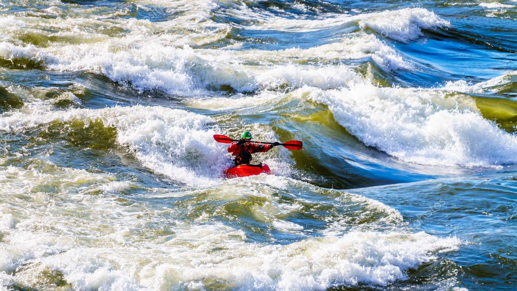 Kayaker navigating through the White Waters of the Thompson River as the river winds  through the Fraser Canyon in British Columbia, Canada