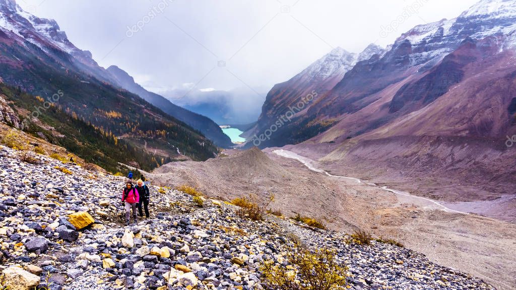Senior women hiking on the moraines of the Victoria Glacier from the Plain of Six Glaciers Teahouse to the to the Six Glaciers at Lake Louise in Banff National Park, Alberta, Canada
