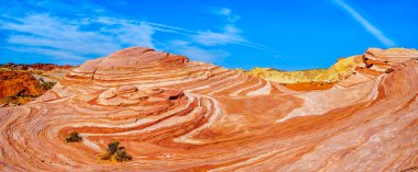 Nevada, ABD'deki Valley of Fire State Park'taki Fire Wave Trail'in sonundaki renkli kırmızı, sarı ve beyaz bantlı kaya oluşumları arasında ünlü Wave Rock'ın panorama görünümü