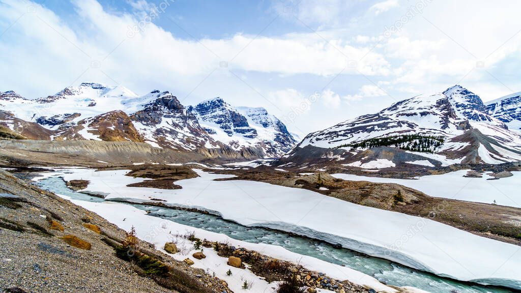 Glacial water from the Athabasca Glacier and Dome Glacier in the Columbia Icefields flowing into the Athabasca River in Jasper National Park, Alberta, Canada at spring time