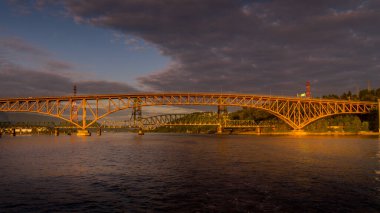 Trans Canada Karayolu üzerindeki İkinci Dar Köprü (Ironworkers Bridge) ve Burrard Körfezi ve Vancouver Limanı üzerindeki Demiryolu Köprüsü üzerinde gün batımı