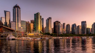 Vancouver, British Columbia / Canada - 11 Temmuz 2019: Vancouver Kömür Limanı kıyısındaki High Rise Binaları ve Yüzer Uçağı Terminali üzerinde gün batımı