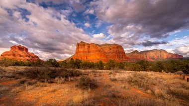 Bell Rock üzerindeki bulutlar ve mavi gökyüzü ve Adliye Binası Butte Oak Creek Köyü ile Kuzey Arizona 'daki Sedona kasabası arasında, Coconino Ulusal Ormanı, Amerika Birleşik Devletleri