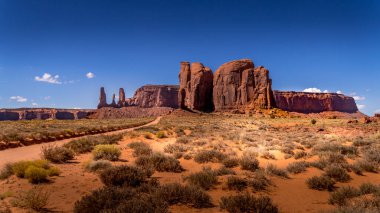 The Three Sisters ve Mitchell Mesa, Monument Valley 'deki Red Sandstone Buttes ve Mesas' ın birkaçı, Utah ve Arizona sınırındaki Navajo Kabile Parkı,