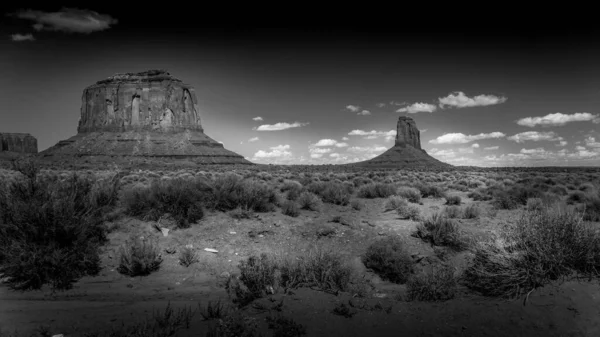 Black and White Photo of the sandstone formations of Merrick Butte and East Mitten Butte in the desert landscape of Monument Valley Navajo Tribal Park in southern Utah, United States