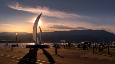 Kelowna, British Columbia/Canada - July 23, 2020: Sunset over the iconic fiberglass sculpture 'Spirit of Sail' at the City Park of Kelowna at the bottom of Bernard Avenue clipart