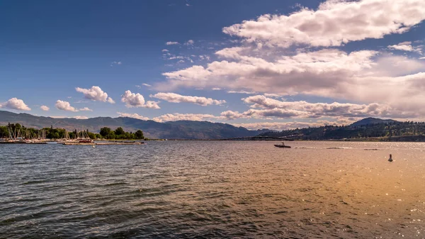 Okanagan Gölü üzerinde, Kelowna City Park 'ın rıhtımında gün batımı. Arka planda 97. otoyolun William R. Bennett Köprüsü var.