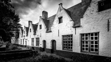 'Prens Beguinage Ten Wijngaarde' in beyaz renkli ön cepheleri ve 1245 'te kurulan sakin manastır bahçesinin siyah ve beyaz fotoğrafı.