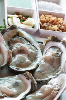 bir şekilde dekore edilmiş çiğ istiridyelerin taze Pasifik büyük grup / kapama jöle hayvan deniz ürünleri Restoran, pişmemiş yiyecek unpearl istiridye, lezzetli yemek tarifi menü taze sebze ve limon garnitür ile