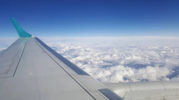 飛行と海外旅行 朝冬時間の旅の背景に乗って曇り青空の翼の飛行機の窓からの眺め — ストック写真