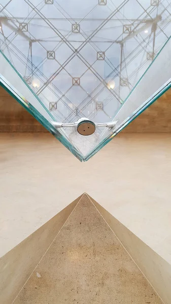 The inverted pyramidal shape in laminated glass points downward towards the floor isolated in white backgrounds, triangular Pyramid Inverse at the famous Louvre museum, Travel destination backgrounds