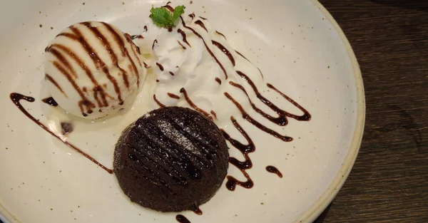 초콜릿 모양의 초콜릿 케이크에 바닐라 아이스크림 크림을 곁들인 소스가 레스토랑에 — 스톡 사진
