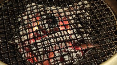 Siyah çelik ızgara kovasında ızgara kömür, ızgara kovasının yanında bronz kapaklı havalandırma vantilatörü, yaz partisinde ızgara kovası, restoranda mutfak malzemeleri.