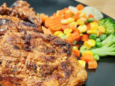 Dilimlenmiş organik domuz eti, çeşitli rengarenk sebzelerle süslenmiş biftek, ahşap masada beyaz tabakta servis edilen bezelye aromalı limon sosu, sokak yemekleri restoranının ünlü gizli tarifi, yemek stilisti.